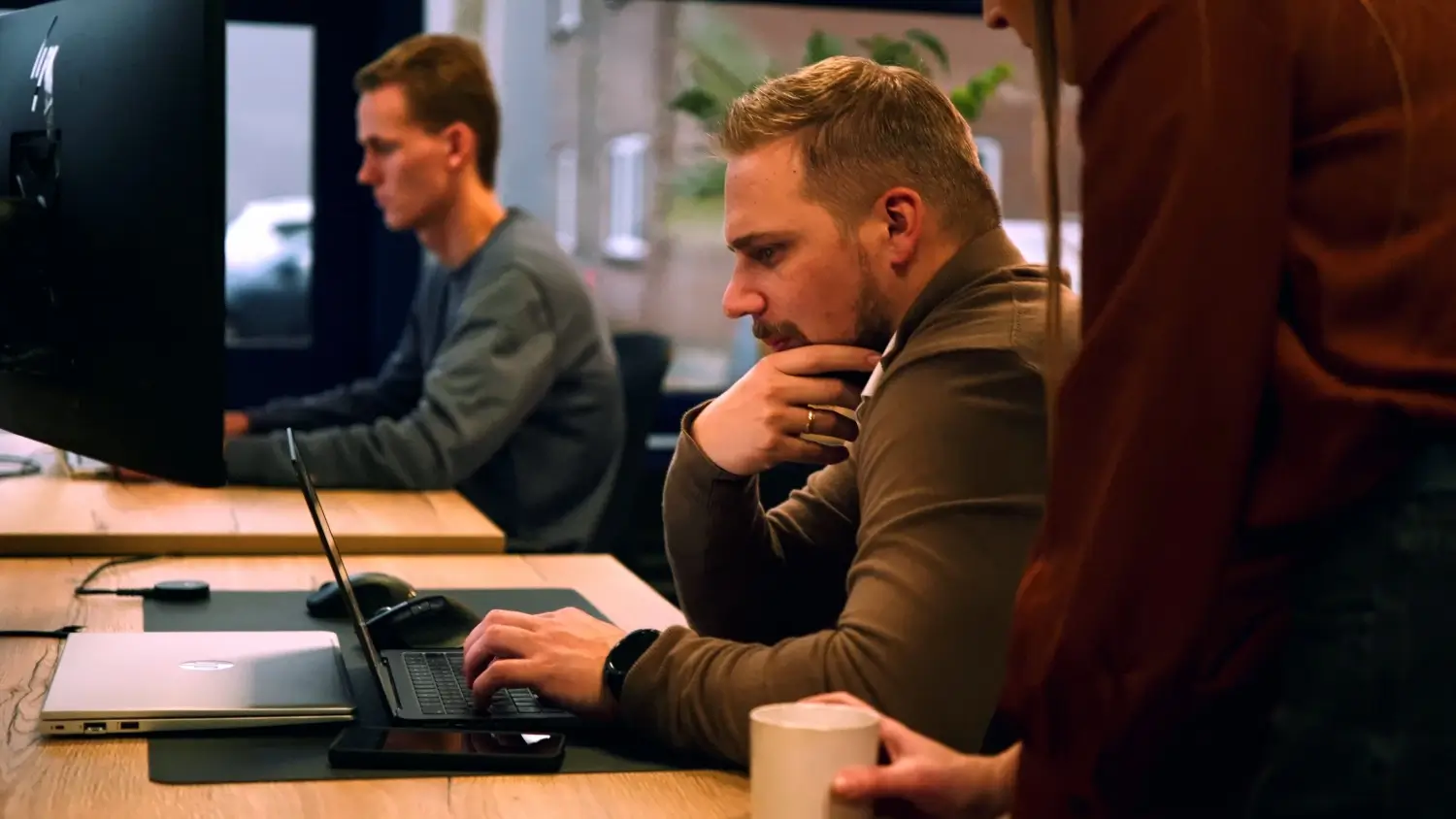 Marketingteam werkt geconcentreerd aan website op laptop